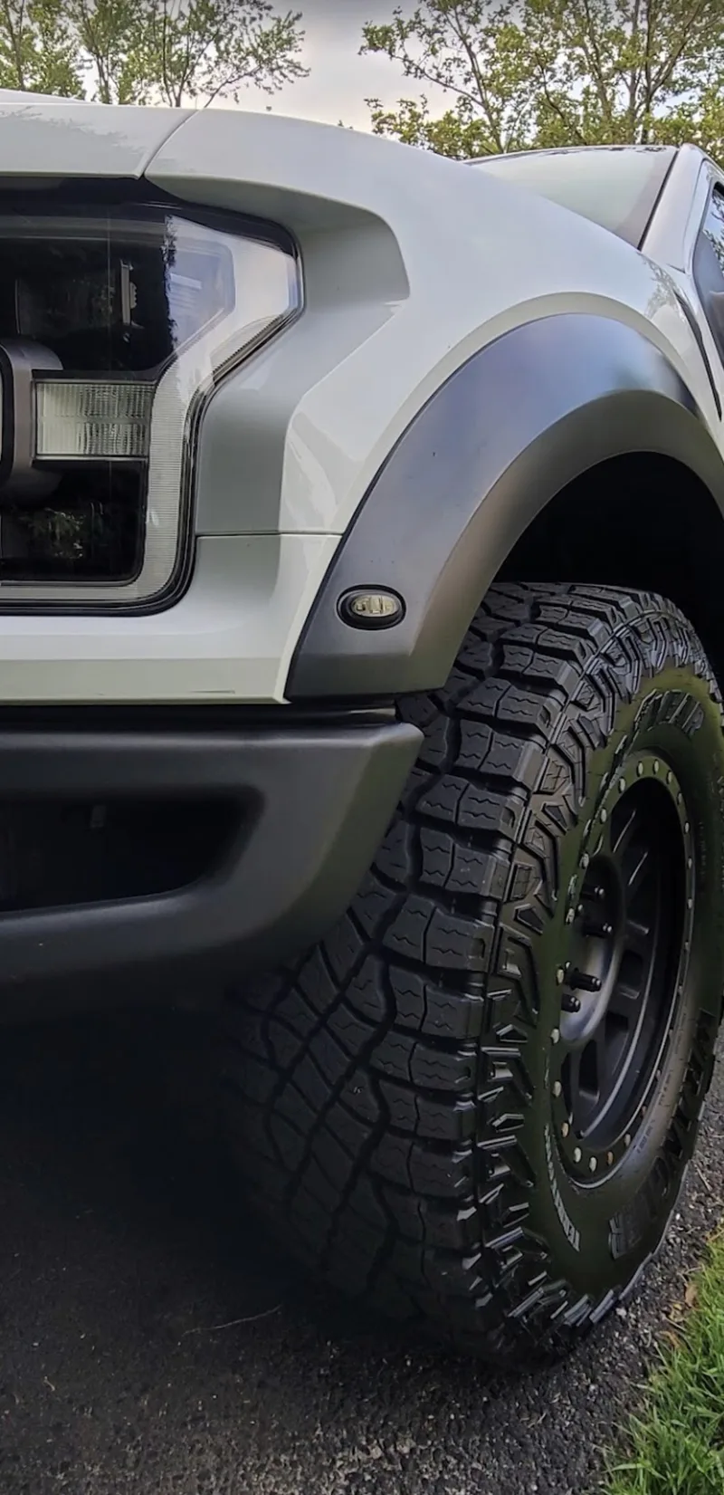 White Ford F-150 Raptor front end and tire after a detail